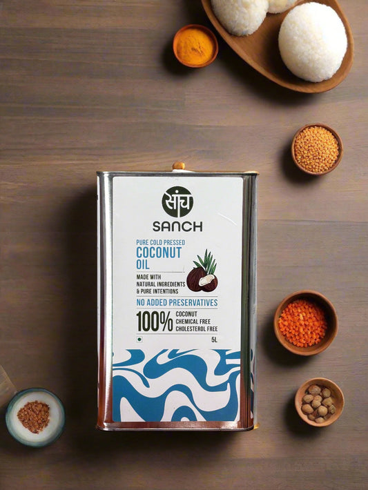 Can of Sanch coconut oil on a wooden surface with a metallic background