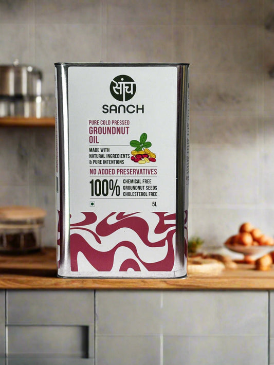 Sanch groundnut oil can on a wooden surface with a gray background