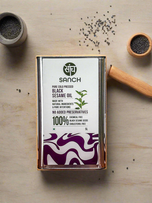 Sanch black sesame oil canister on a wooden surface with a metallic background